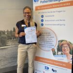 Carmen A.J. Teemer hält stolz ihr erhaltenes Zertifikat als ausgebildete Patientenbegleiterin in der Hand.
